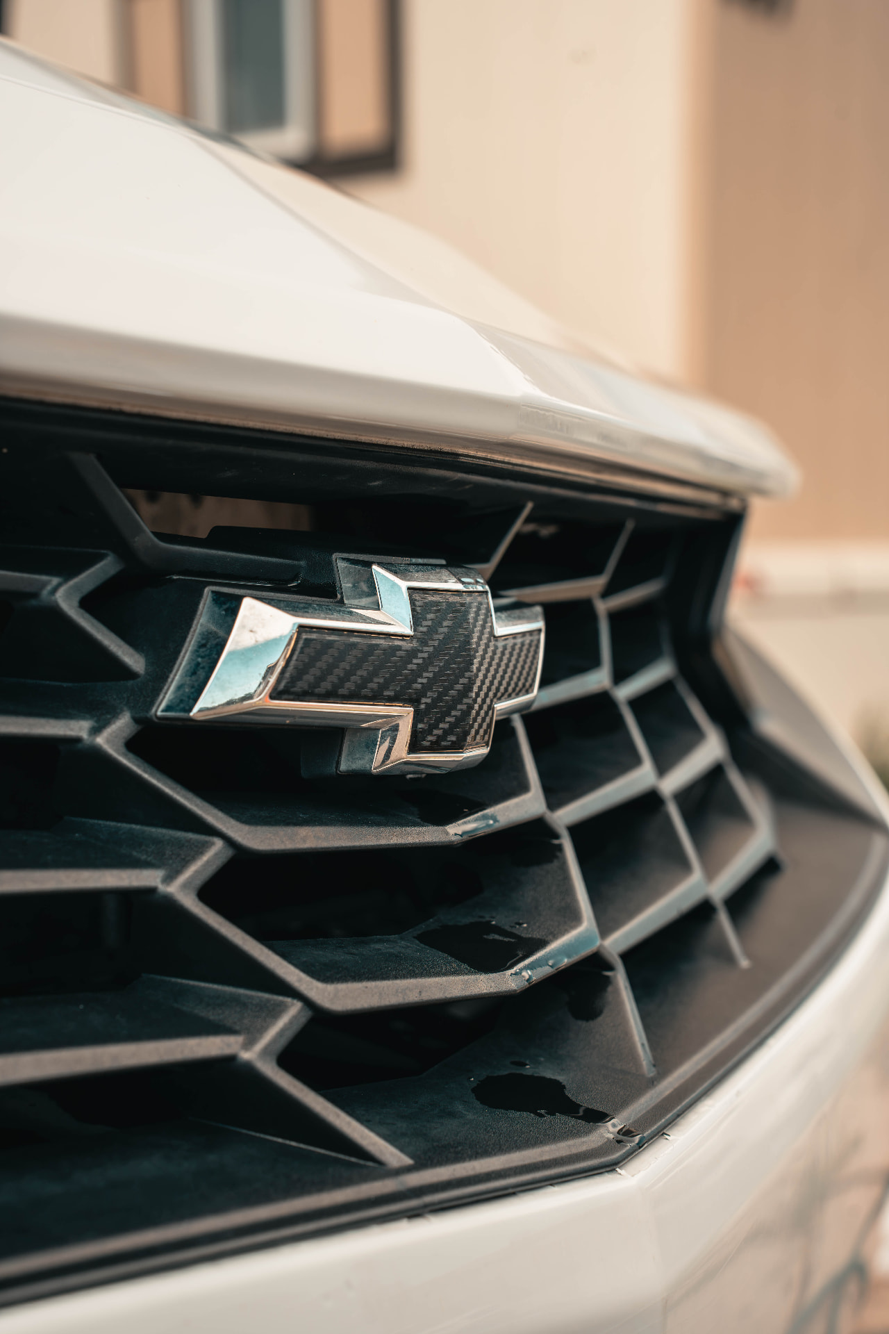 Freshly cleaned carbon fiber Chevrolet bowtie on a front grille