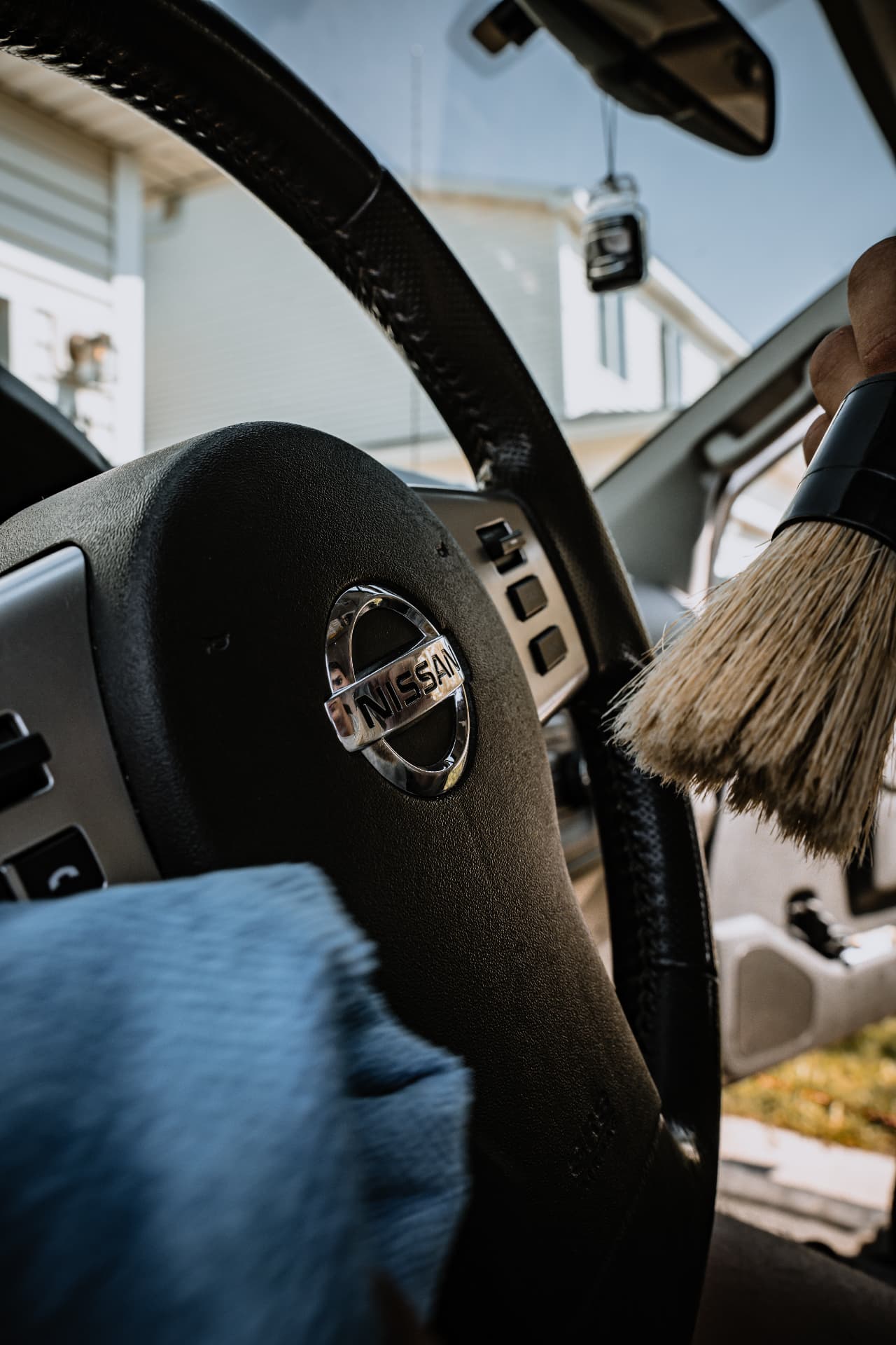 Detail brush dusting the interior of a Nissan truck
